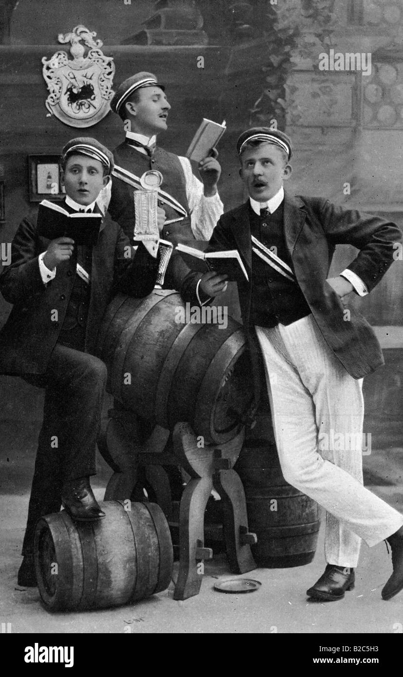 Gli studenti di fraternità cantando accanto a barili di birra, tenendo una song book, foto storiche da circa 1910 Foto Stock