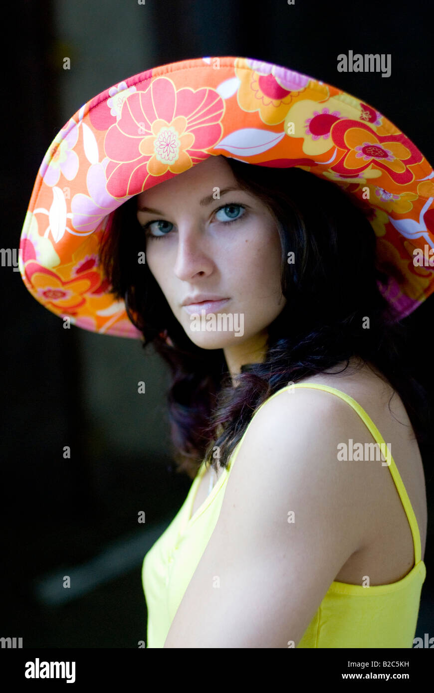 Carino dai capelli scuri con la donna un multicolore hat Foto Stock