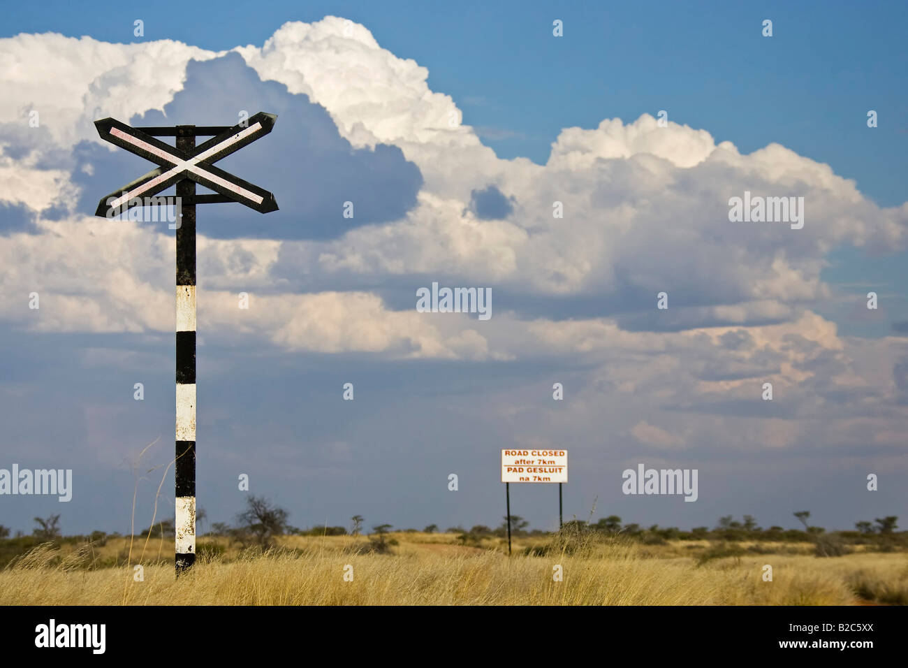Avvertenza croce davanti a un attraversamento ferroviario, della lettura del segno Strada chiusa dopo 7 km, Namibia, Africa Foto Stock