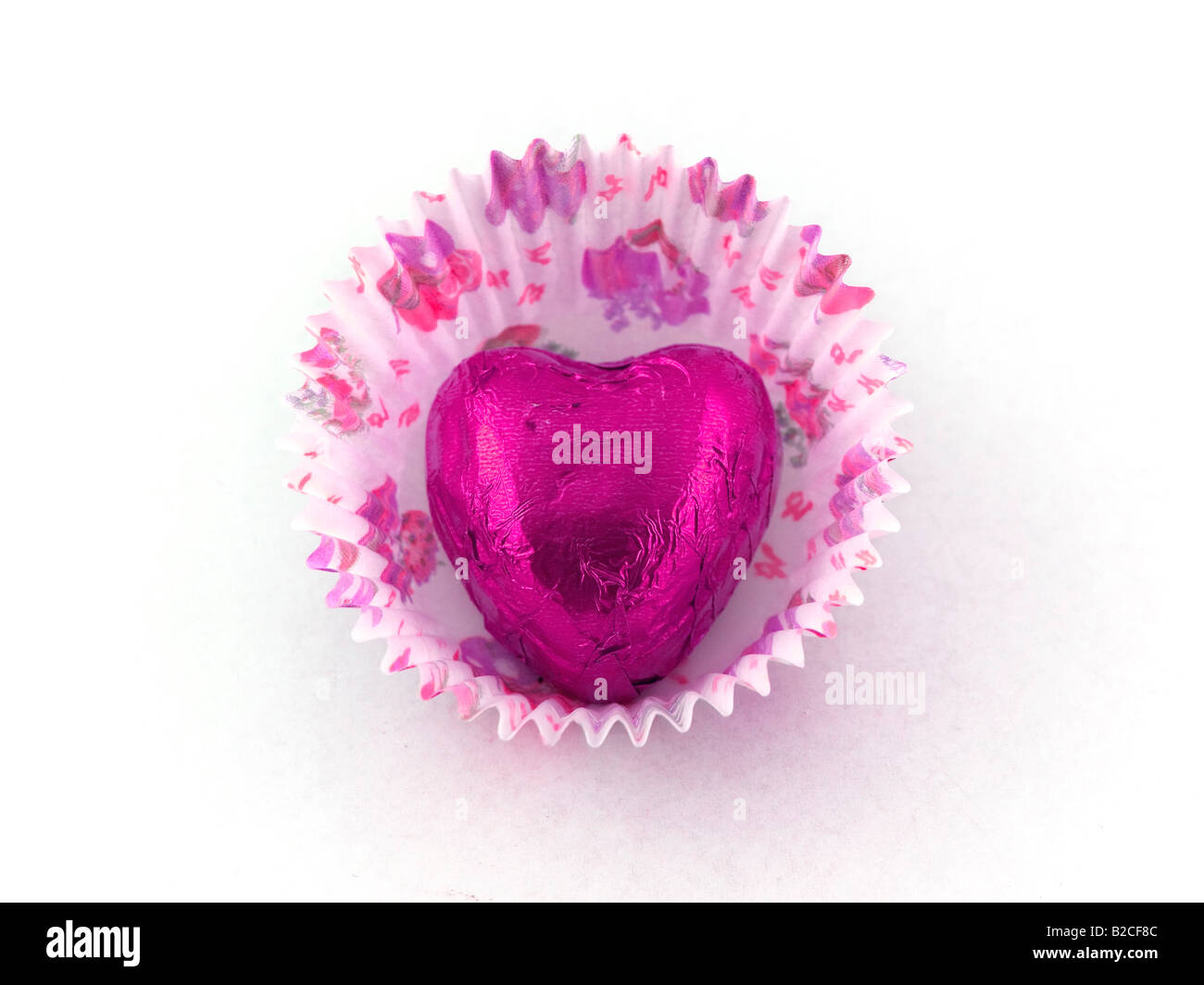 Cuore rosa cioccolato nella torta di carta caso Foto Stock