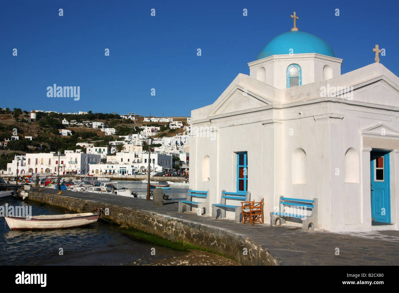 Il vecchio porto di Mykonos isola con una piccola chiesa bianca in primo piano Foto Stock
