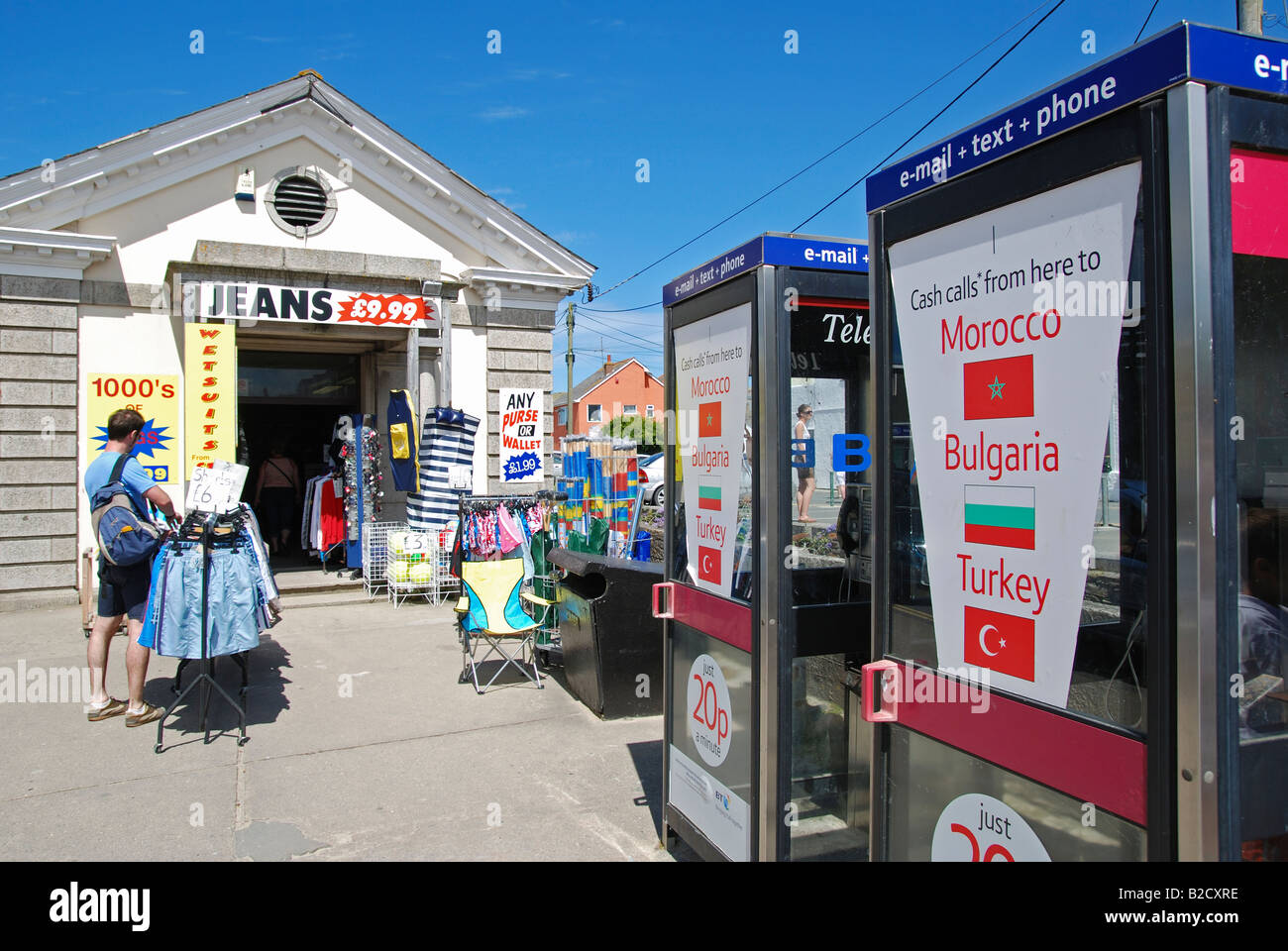 Le cabine telefoniche al di fuori di un negozio sulla spiaggia a perranporth,cornwall, Regno Unito Foto Stock