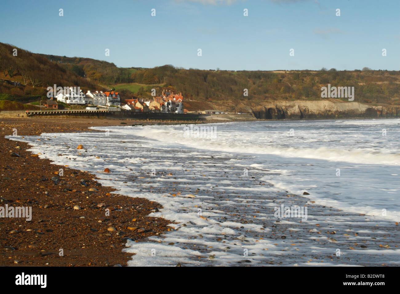 Sandsend spiaggia con le onde in arrivo e lavaggio su ghiaia sabbia coperte Foto Stock