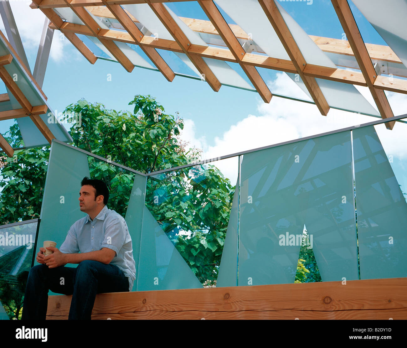 Uomo seduto nel padiglione con un caffè, Serpentine Gallery Pavilion 2008 Londra UK architetto Frank Gehry Foto Stock