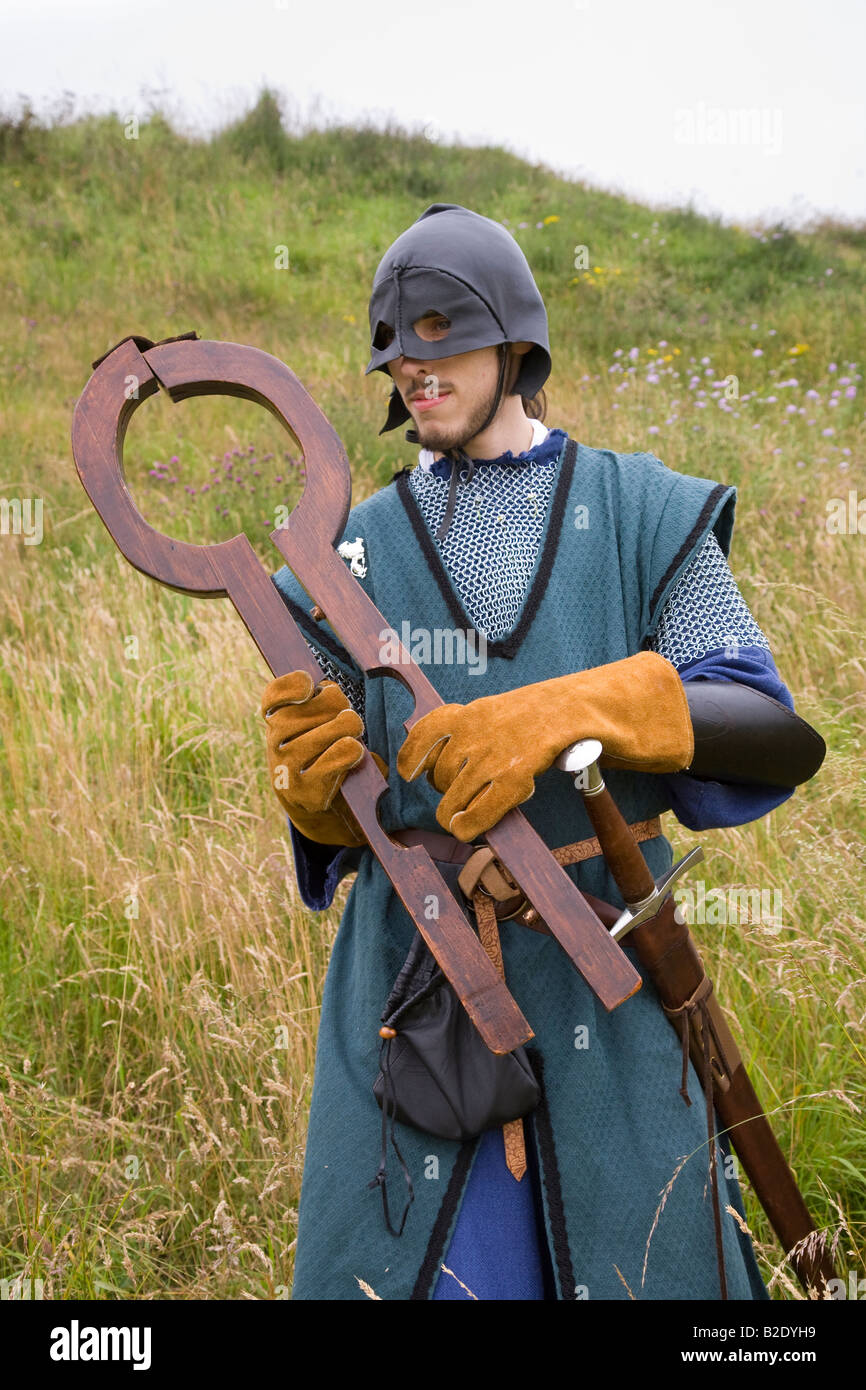 La megera Fiddle o megera di Fife, legno di ritenuta bocchettone detenute da giustiziere mascherato (MR) a cavalieri di Monymusk, rievocazione gruppo, Scozia UK. Foto Stock