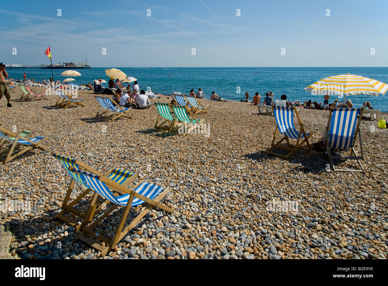 Sedie a sdraio e turisti sulla Spiaggia Brighton East Sussex England Foto Stock