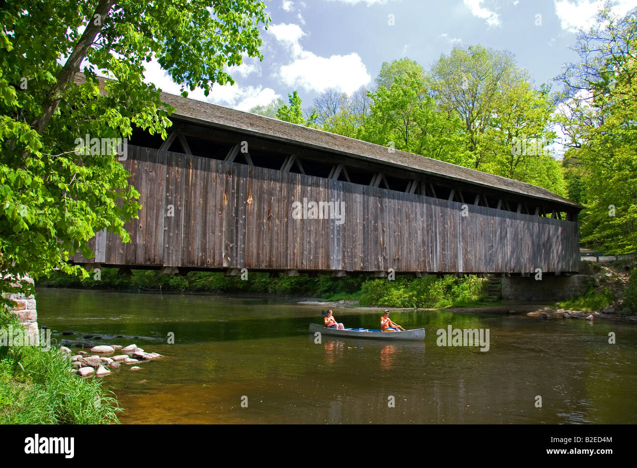 Canoa passando sotto i bianchi ponte sul fiume piatta in Keene Township Michigan Foto Stock