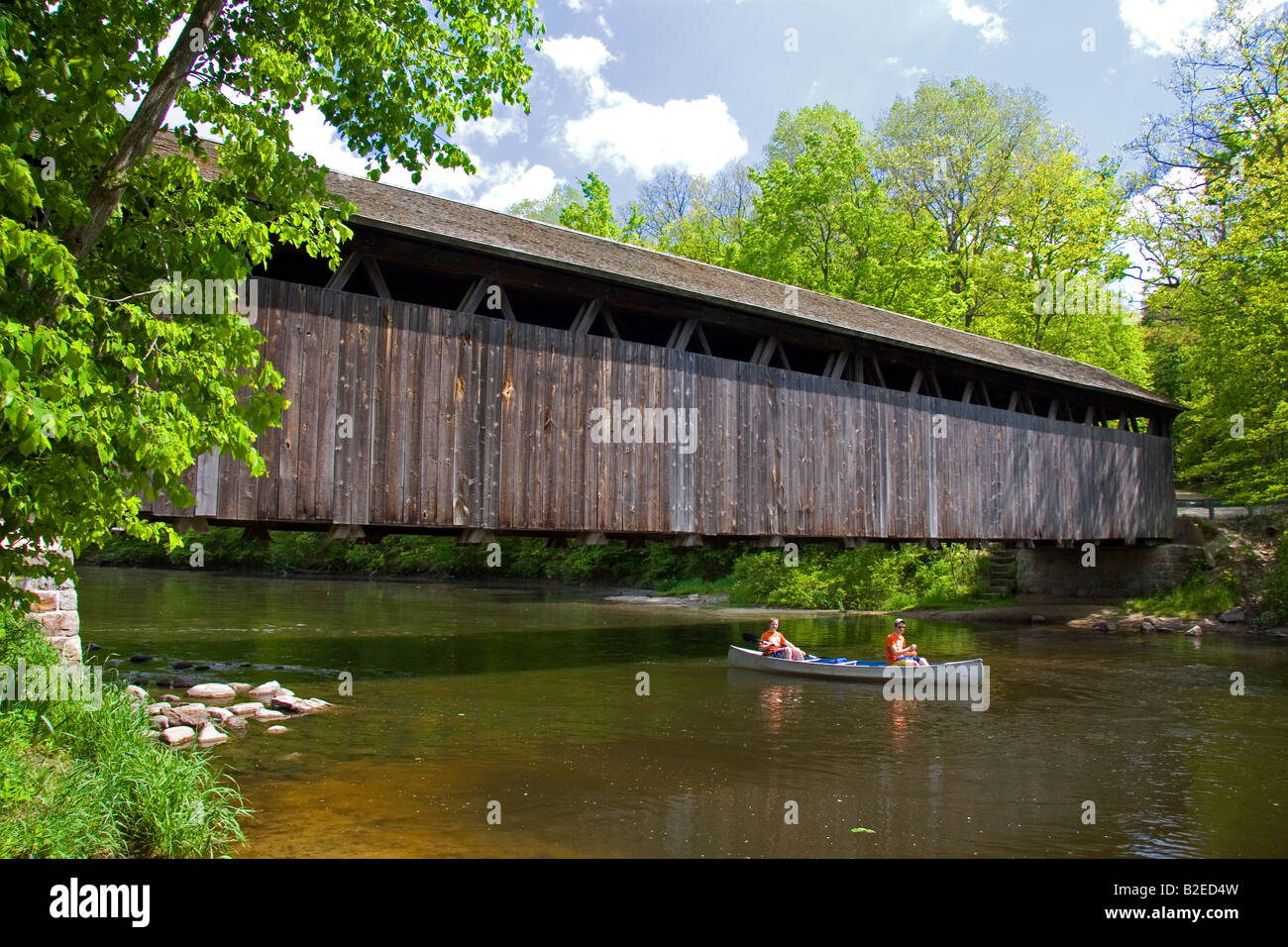 Canoa passando sotto i bianchi ponte sul fiume piatta in Keene Township Michigan Foto Stock