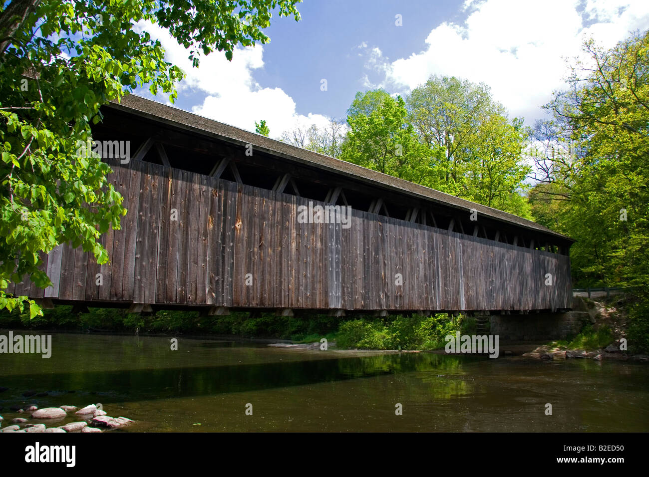 I bianchi ponte un traliccio marrone coperto ponte che attraversa il fiume piatta in Keene Township Michigan Foto Stock