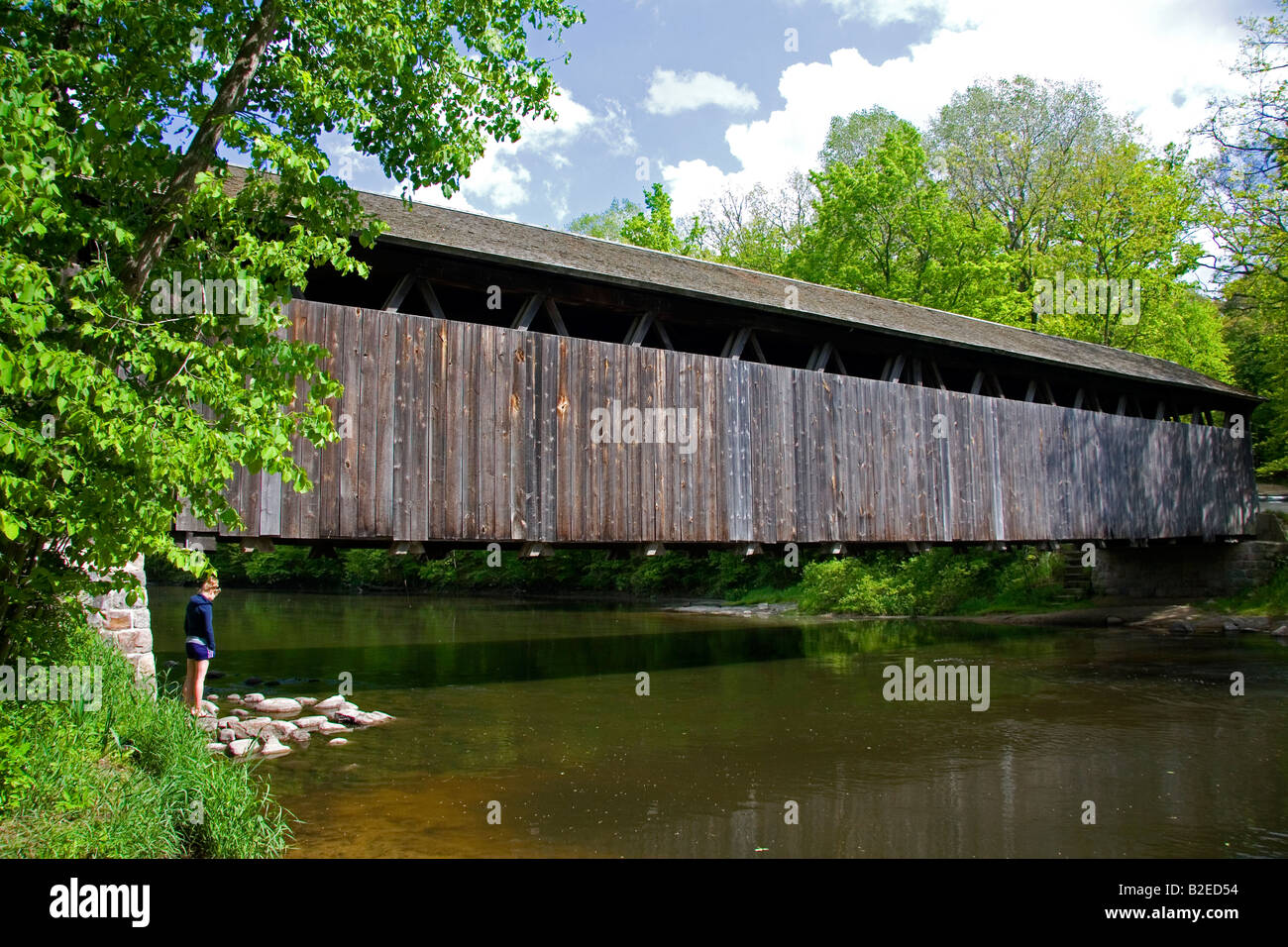 I bianchi ponte un traliccio marrone coperto ponte che attraversa il fiume piatta in Keene Township Michigan Foto Stock