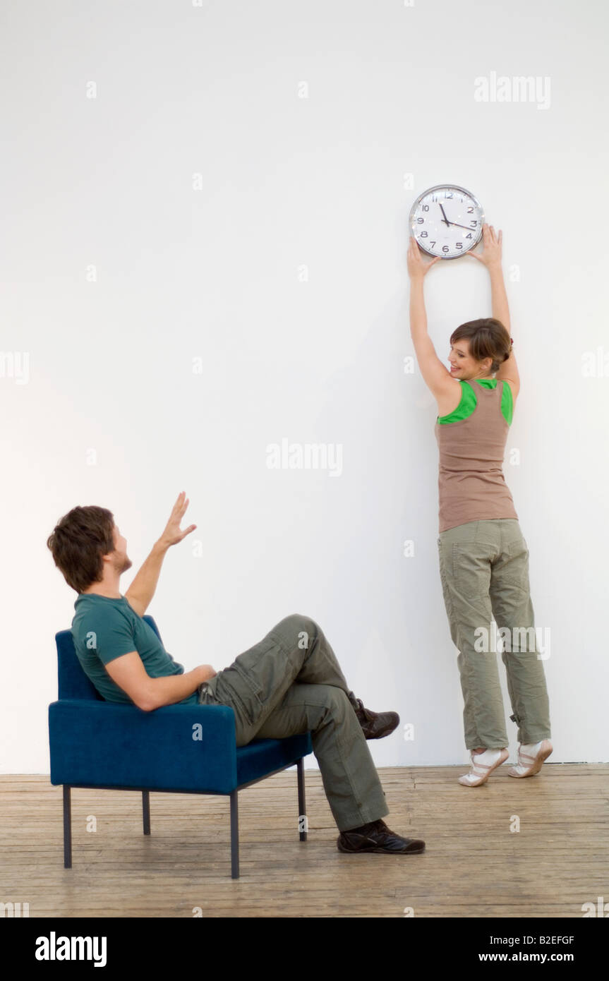 Metà uomo adulto guardando a sua moglie il montaggio di un orologio da  parete Foto stock - Alamy