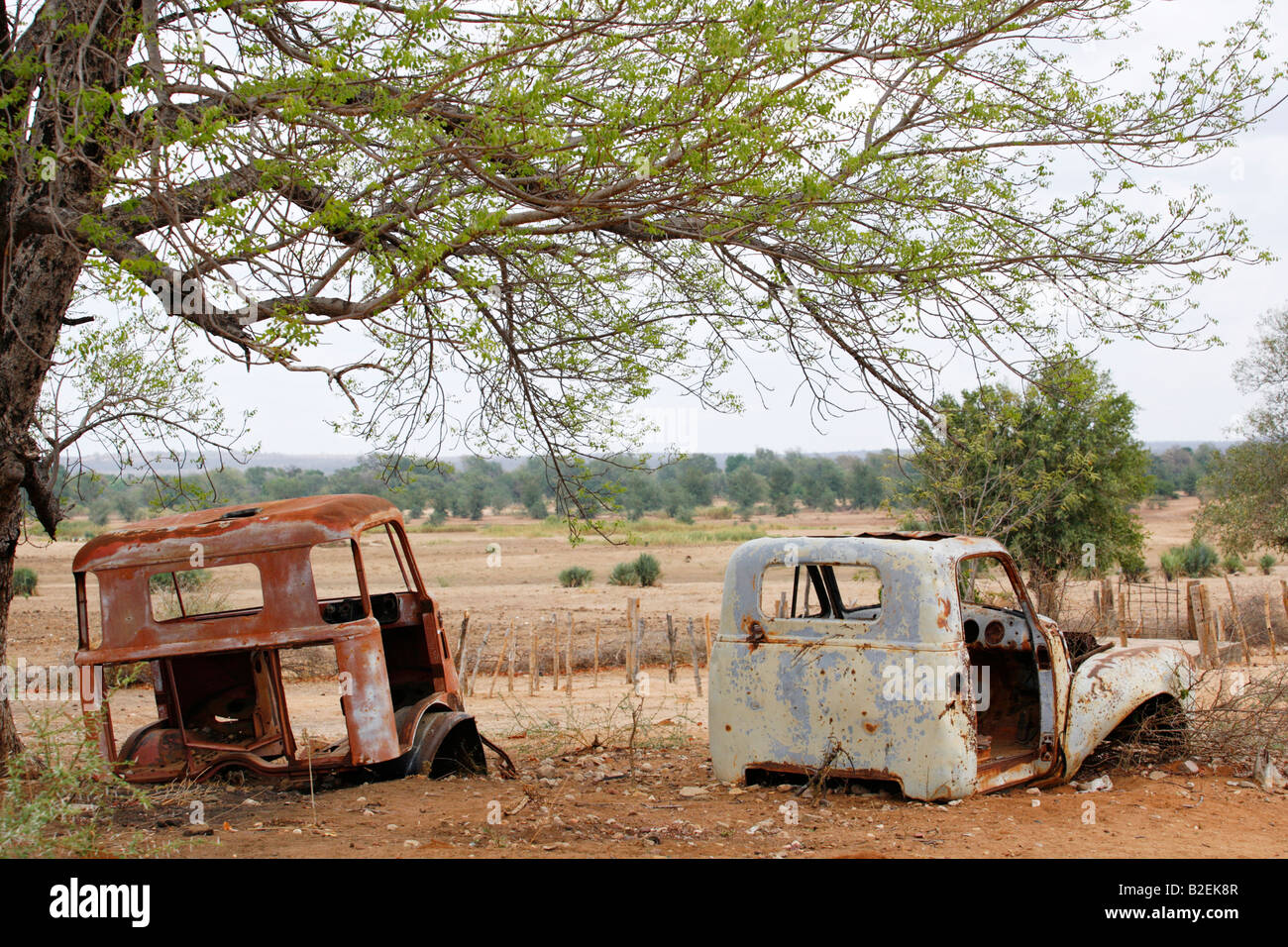 La formazione di ruggine resti di due carrelli a sinistra dopo la guerra civile sotto un albero in Mapai - un ex roccaforte Renamo Foto Stock