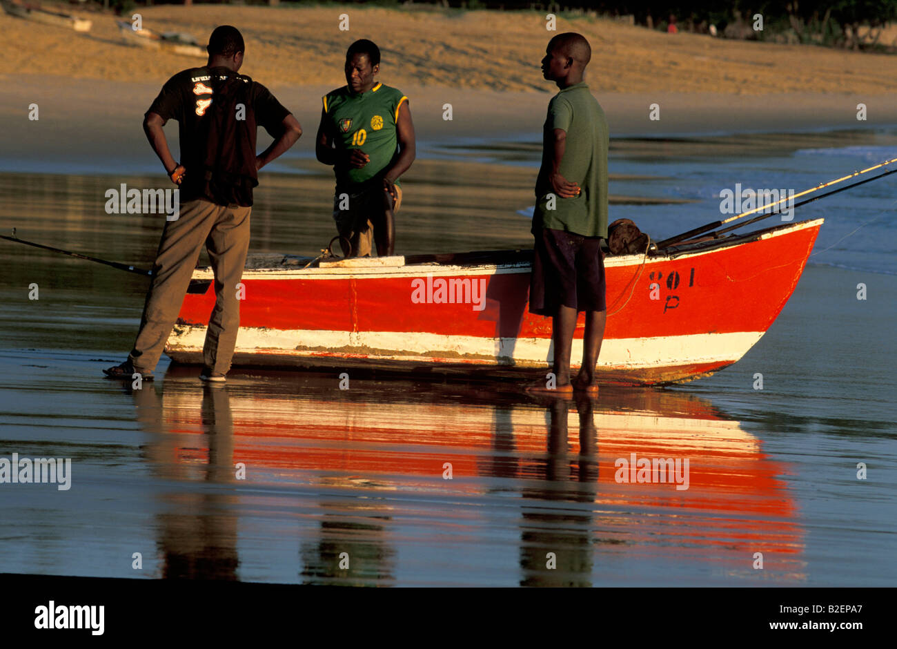Tre pescatori con dipinto luminosamente barca Foto Stock