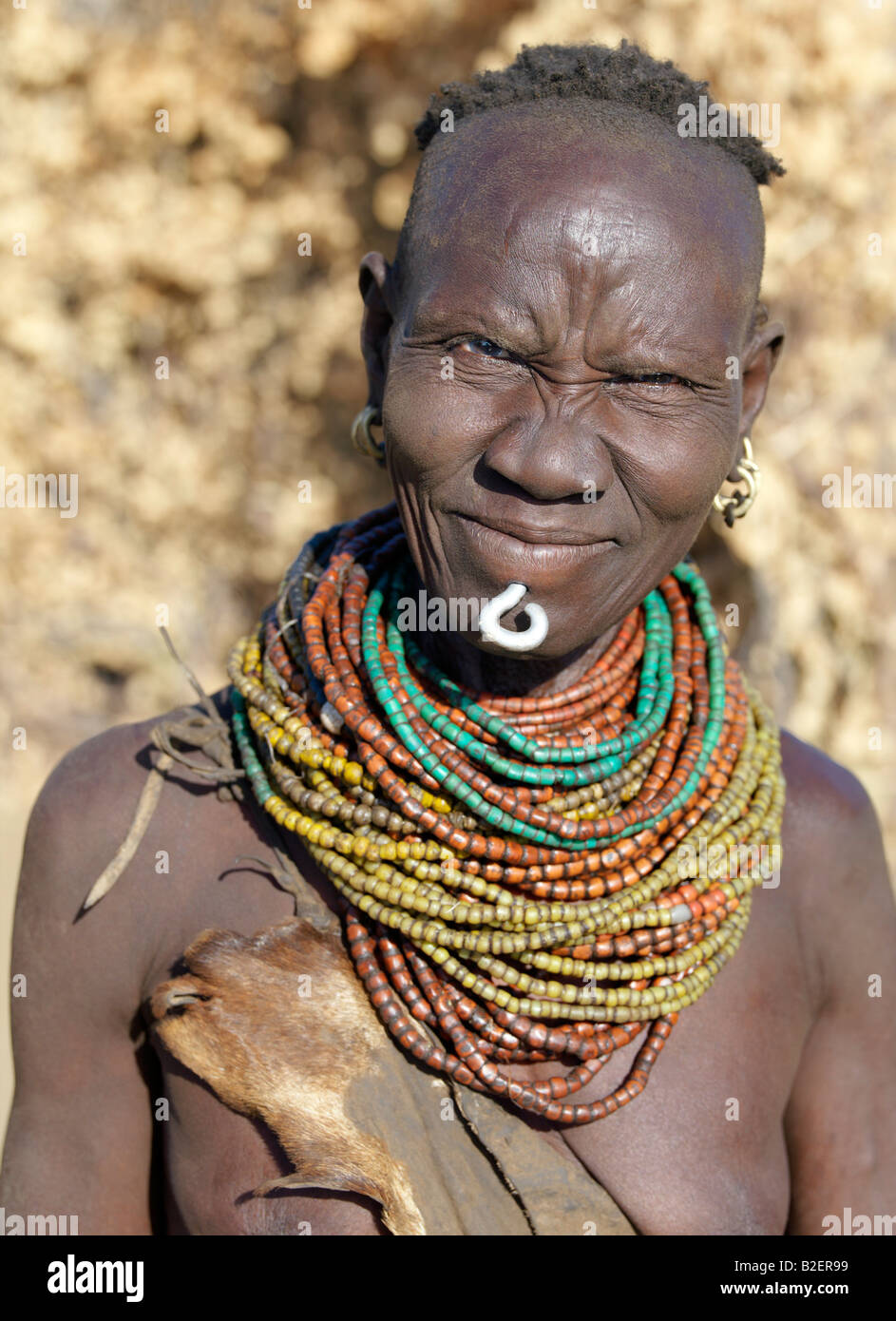 Un vecchio Nyag'atom donna che indossa un labbro metallico ornamentale nel foro praticato sotto il suo labbro inferiore. Foto Stock