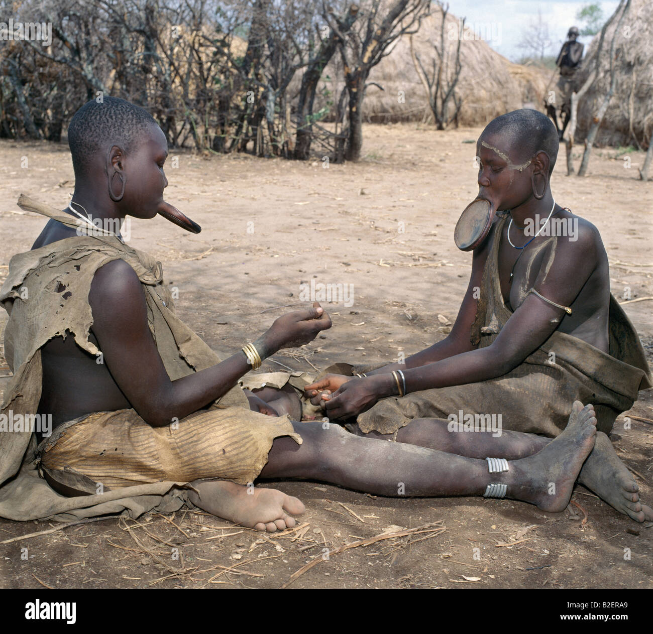 Due donne dei Mursi indossando grande argilla piastre a labbro si scambiano un ornamento. Foto Stock