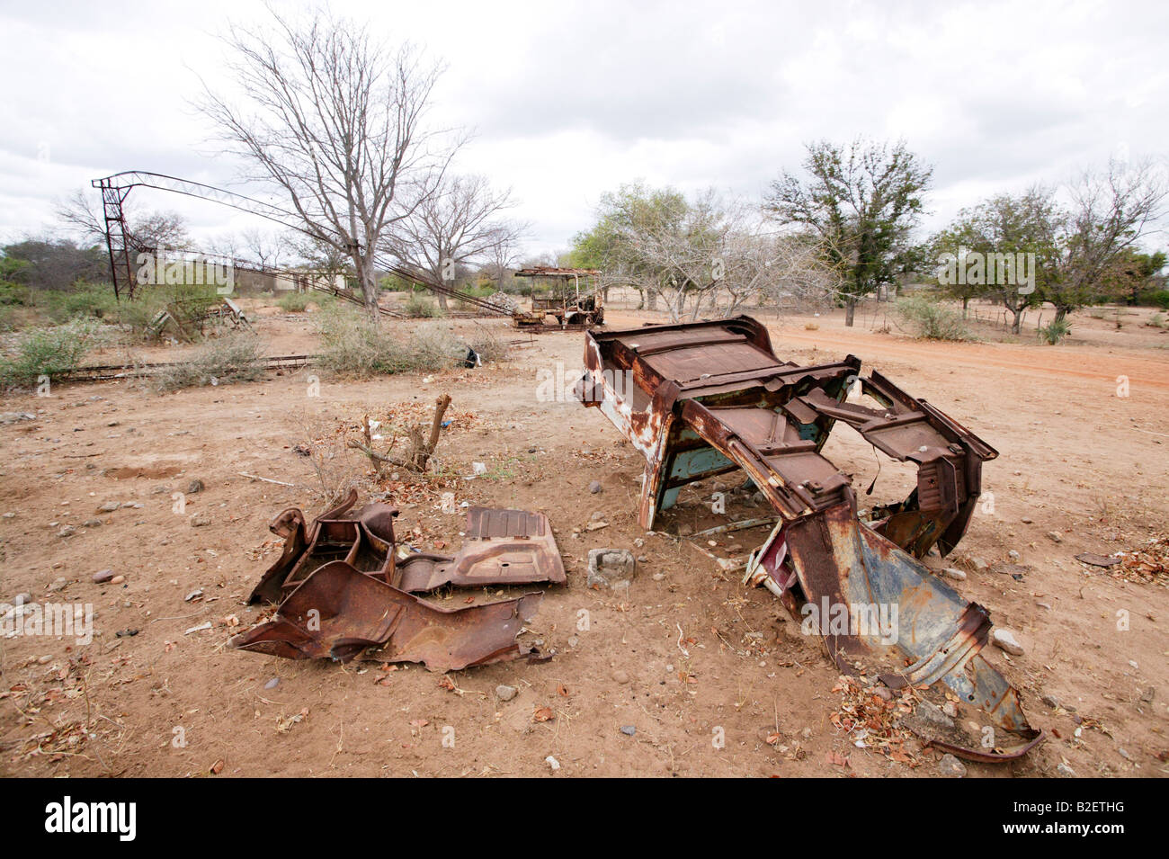 Il bombardato resti di un carrello e piegate le strutture del tetto di un edificio lasciato in rovine durante il Mozambico guerra di Bush Foto Stock