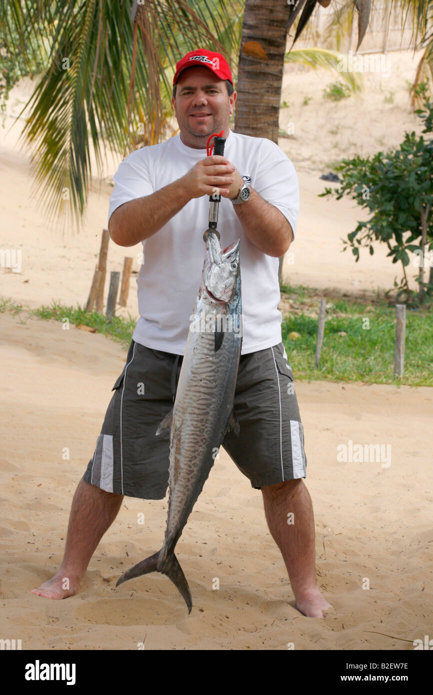 Un orgoglioso pescatore tenendo premuto fino a Cuta catturati al largo della costa del Mozambico Foto Stock