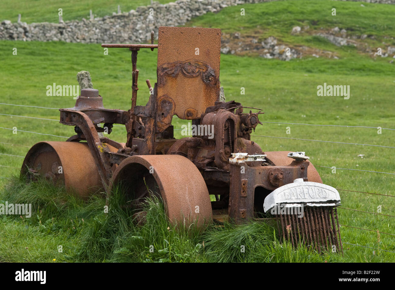 Barford rullo, rusty macchinari abbandonati, del pascolo, sul lato della strada, Fair Isle, Isole Shetland Scozia, Giugno Foto Stock