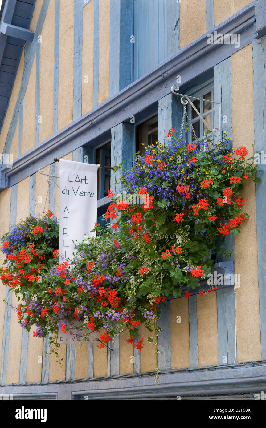Piuttosto nei cestini appesi su metà edificio con travi di legno, Dinan, Brittany, Francia Foto Stock