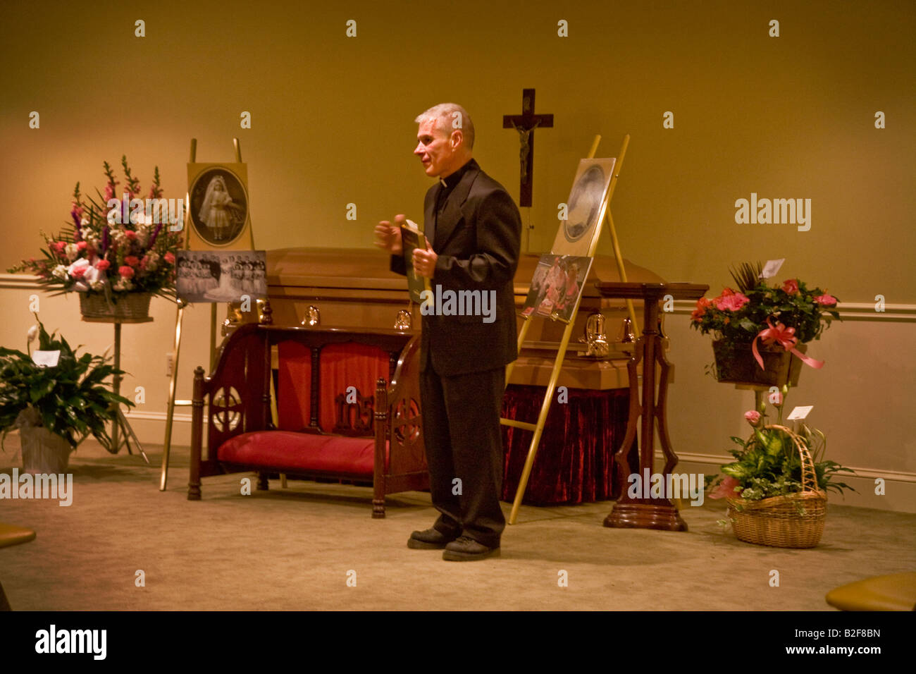 Un sacerdote preghiere conduce a un cattolico di wake in Stoneham ma nota scrigno chiuso e le fotografie del defunto sul display Foto Stock