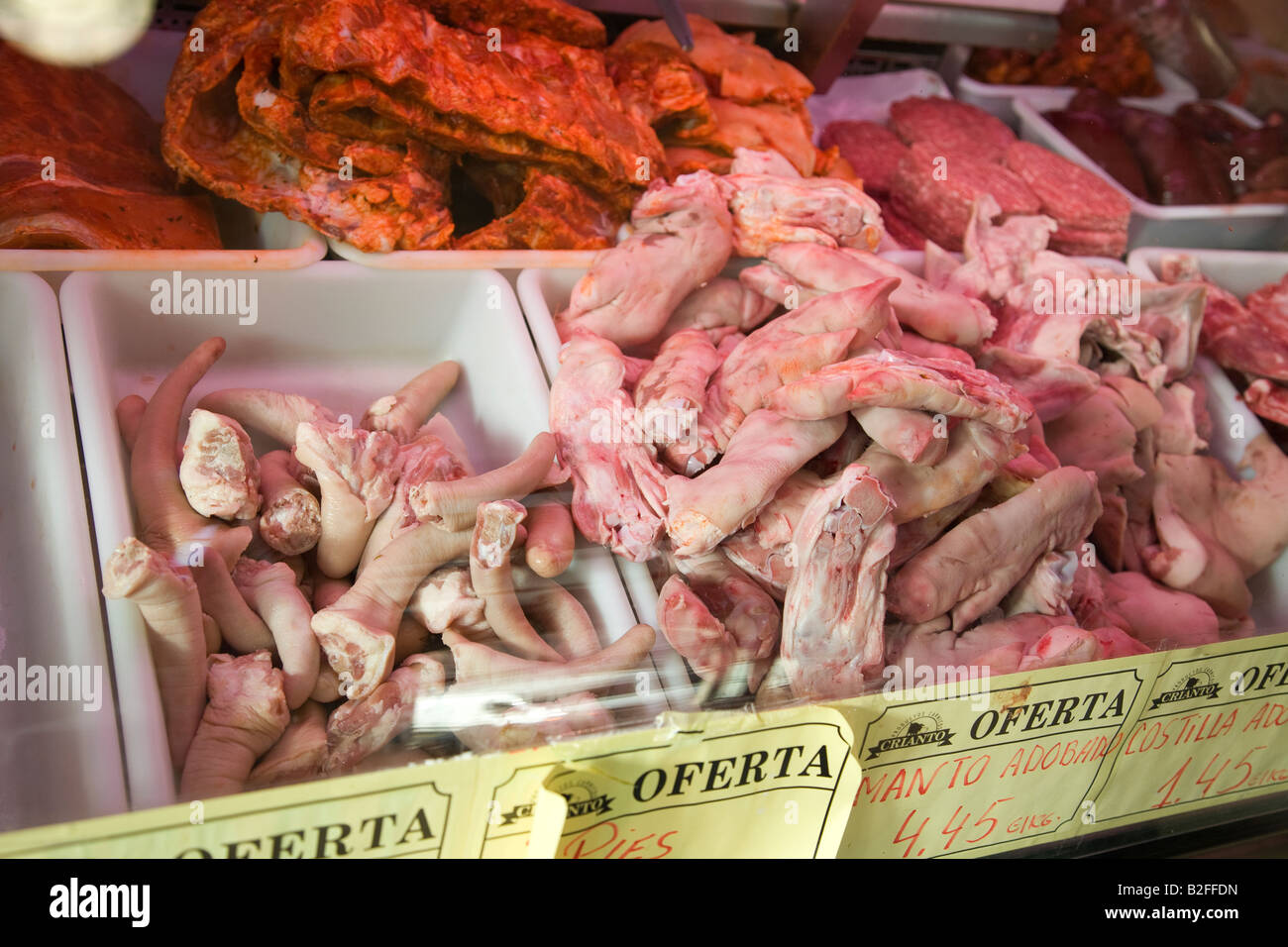 Spagna Salamanca suini i piedi e le code visualizzate in macelleria al mercato giornaliero carni fresche in vetrina Foto Stock