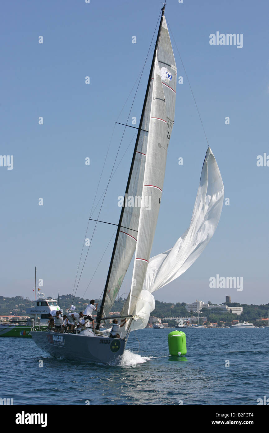 Uno Yacht colpisce il suo spinnaker durante una gara. Foto Stock