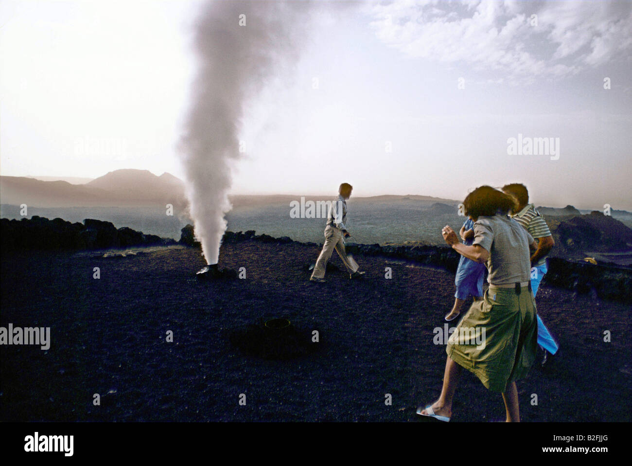I turisti di guardare un vapore vulcanico fumerole a timanfaya fire mountain Foto Stock