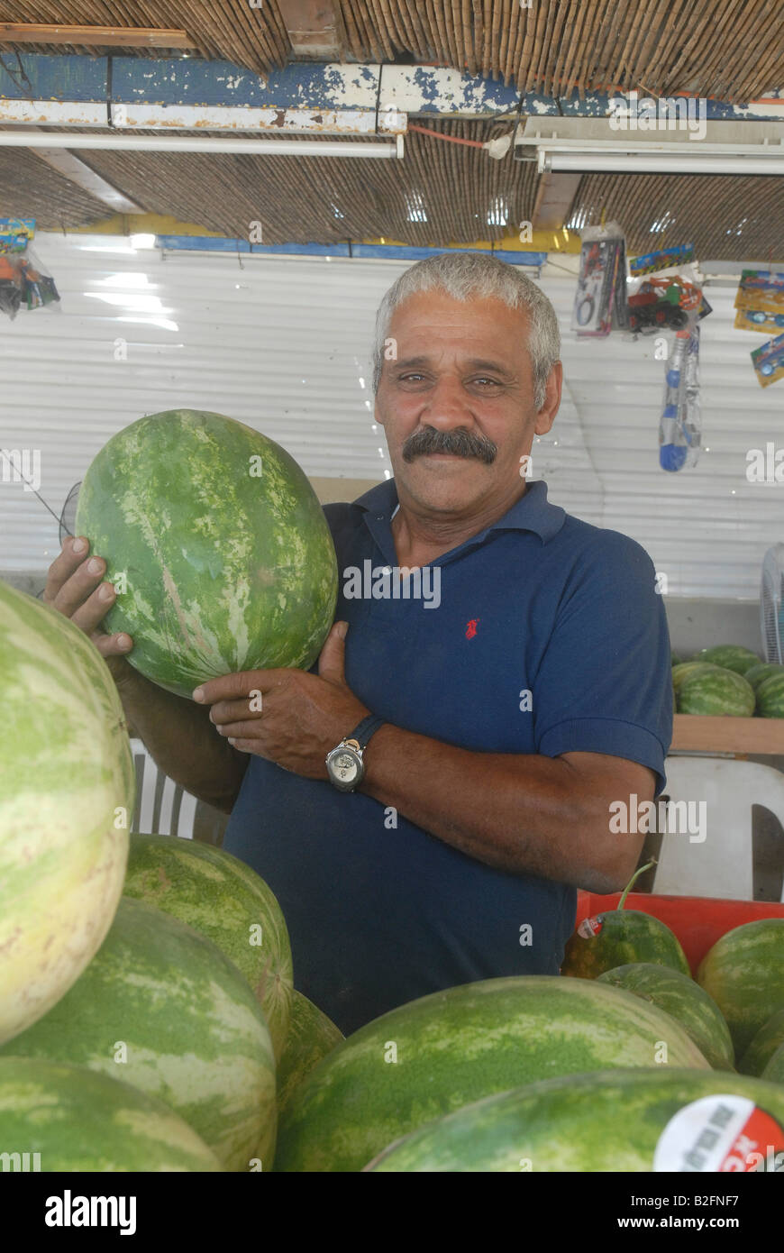 Bancarella vendendo freschi Cocomeri una pila di cocomeri sul display il venditore è orgogliosa di presentare un campione Foto Stock