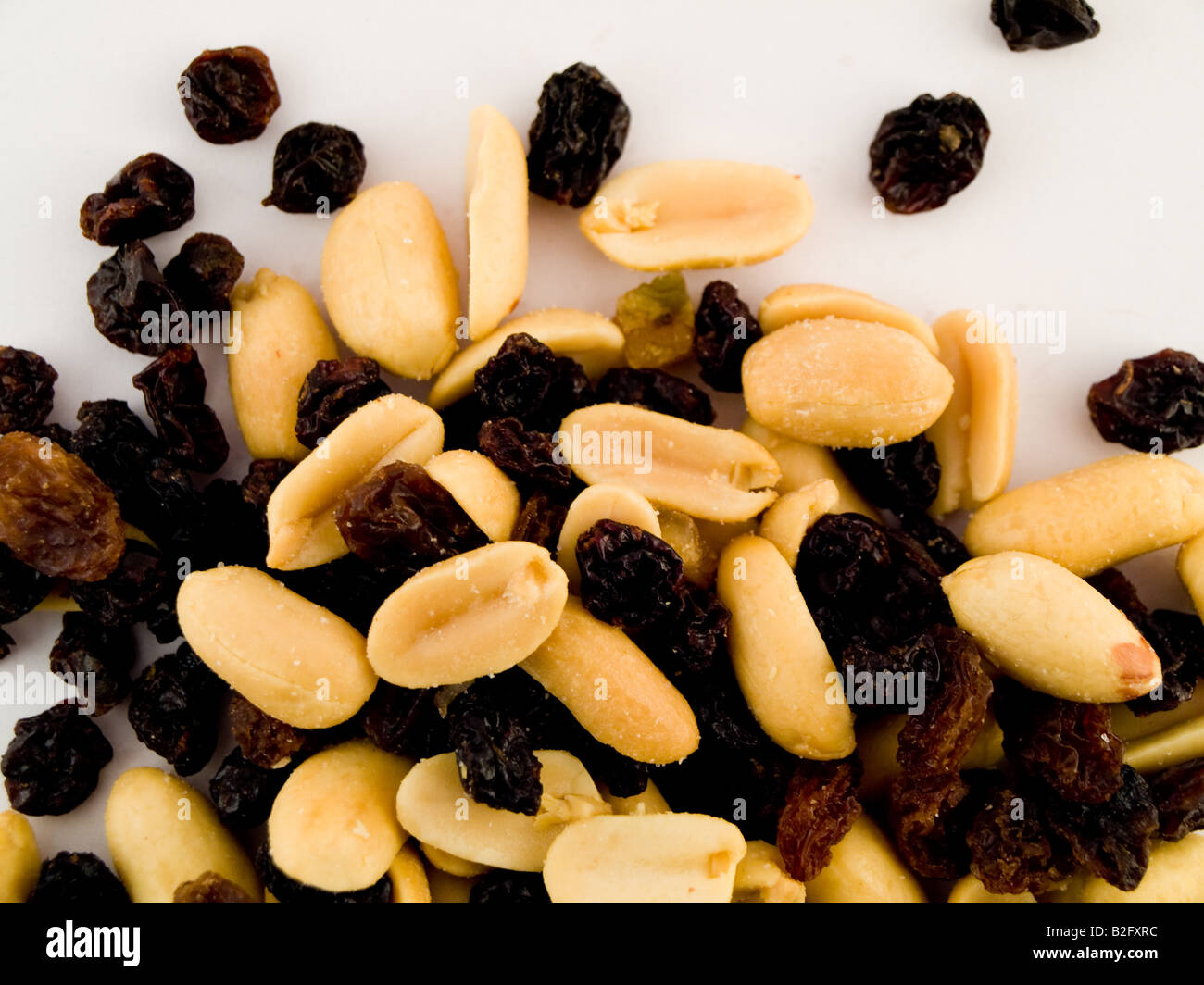 Pila pila di arachidi e uva passa su sfondo bianco n. gusci o rivestimento Foto Stock