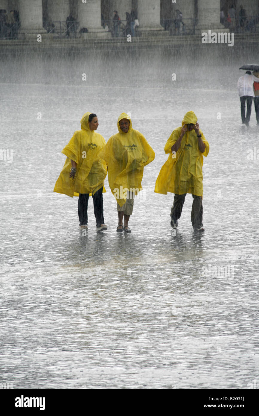 Tre turisti in heavy rain in st peters sq, Roma Foto Stock