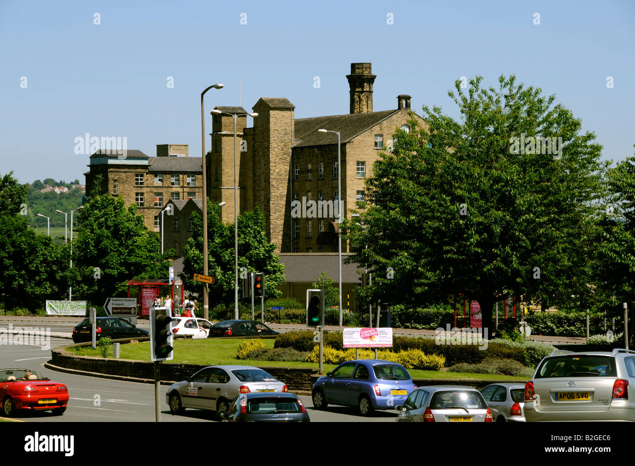 Un anello stradale rotatoria con un mulino oltre a Huddersfield Foto Stock