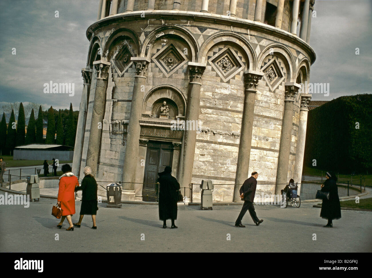 Gli anziani compresi 2 monache a piedi di fronte alla Torre pendente di pisa per una giornata opaca Foto Stock