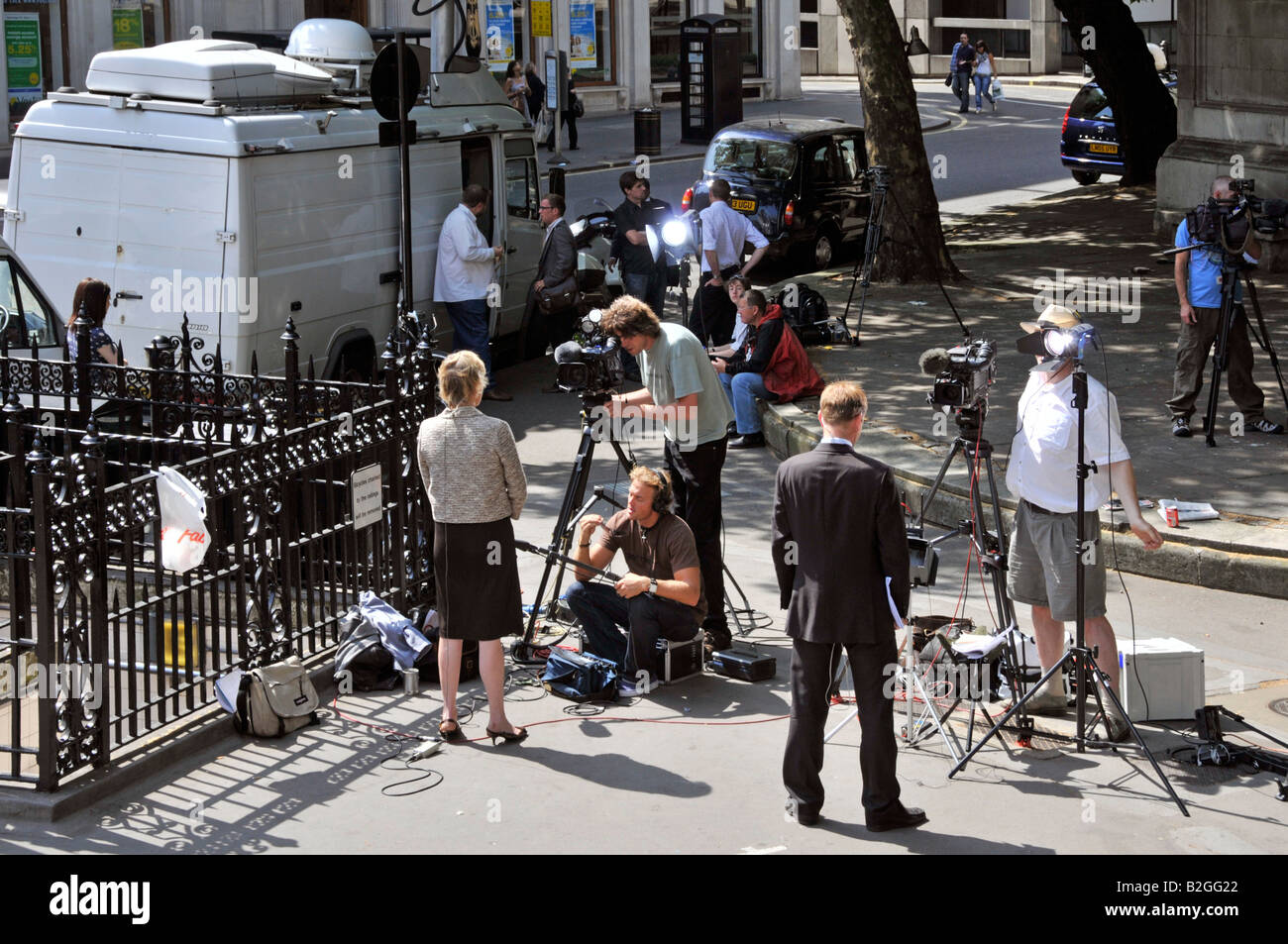 Di fronte al Royal Courts of Justice, giornalisti e giornalisti con telecamere televisive file notizie relazioni oltre parabola satellitare van London UK Foto Stock