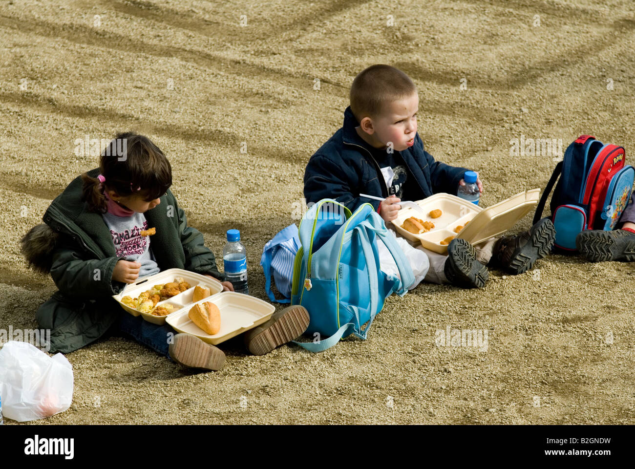 Parco Guell bambini mangiare sul pavimento barcelona Foto Stock