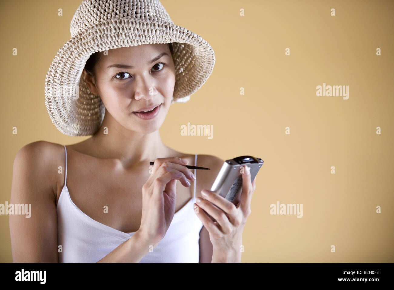 Ritratto di una giovane donna che utilizza un assistente di dati personale e sorridente Foto Stock