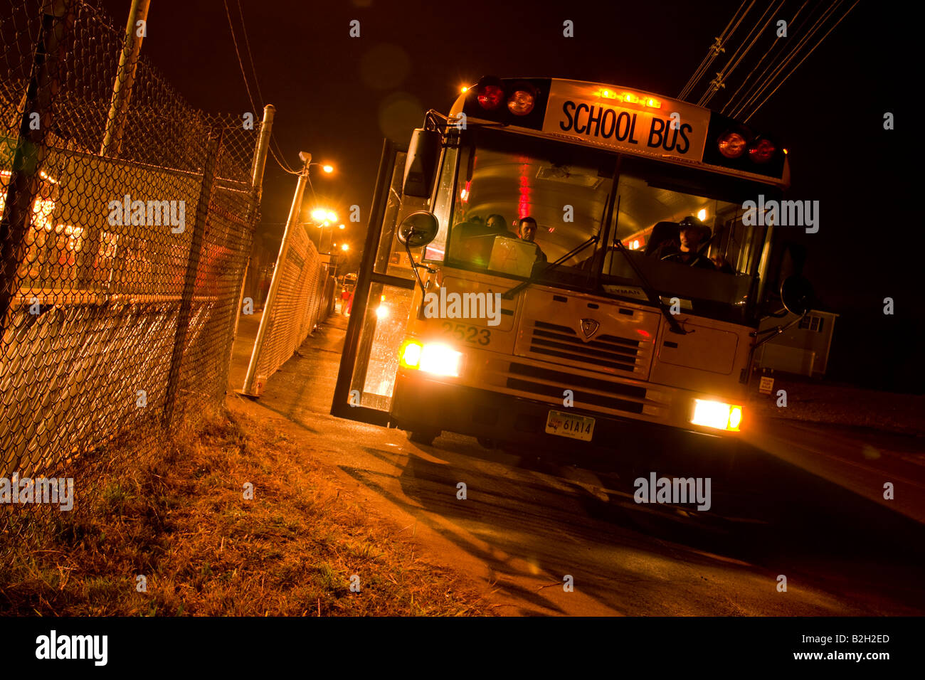Giallo scuola bus a una fiera notturna in attesa di prelevare le persone Foto Stock