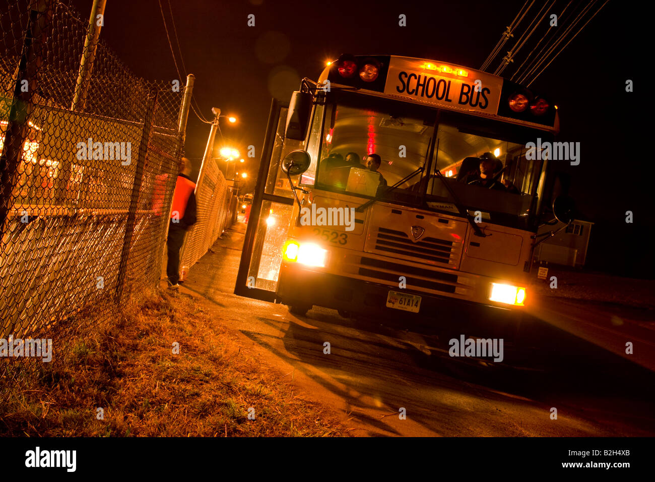 Giallo scuola bus a una fiera notturna in attesa di prelevare le persone Foto Stock