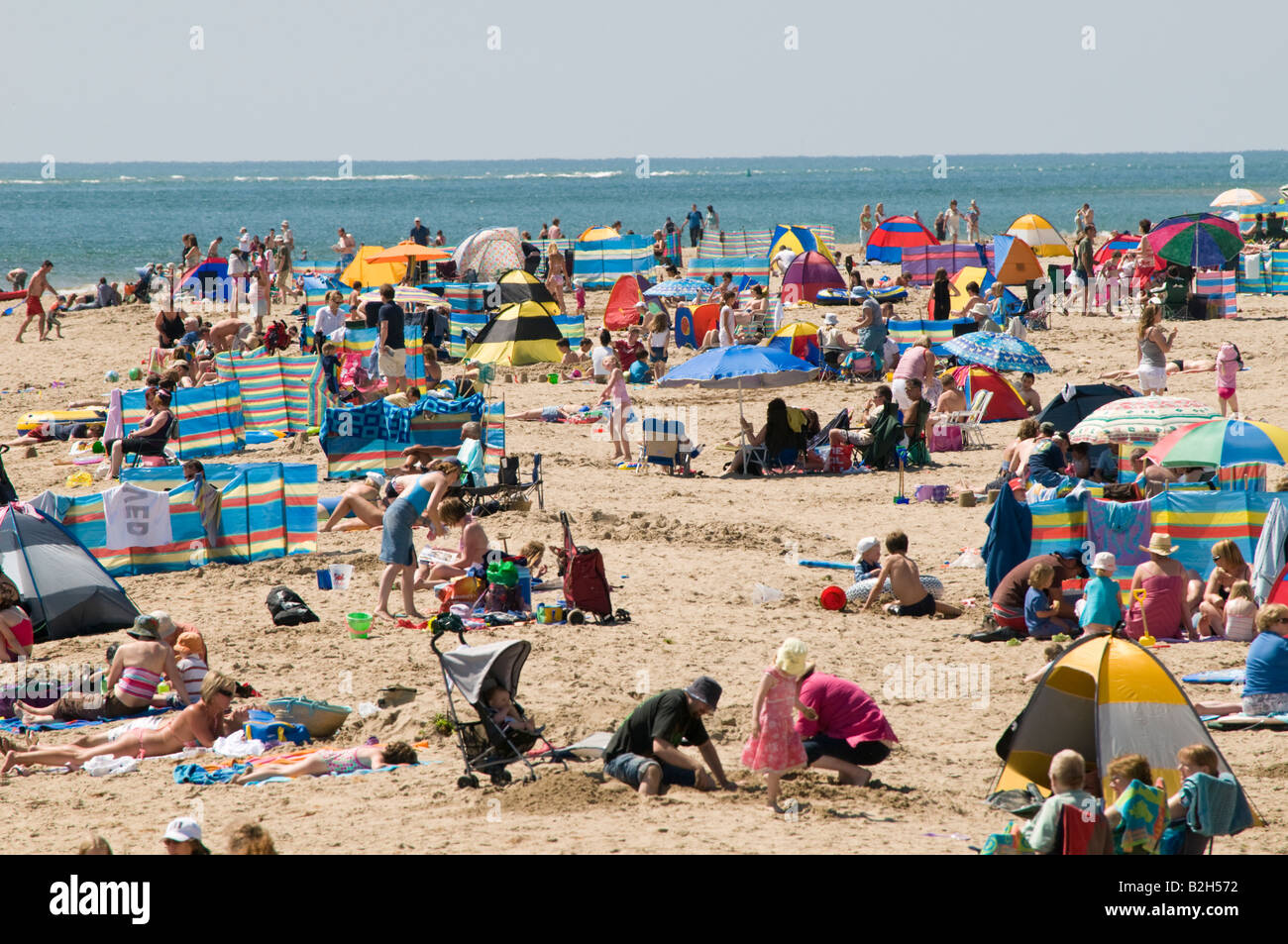 La folla di turisti sulla spiaggia sabbiosa a Aberdyfi Snowdonia Galles pomeriggio estivo Foto Stock