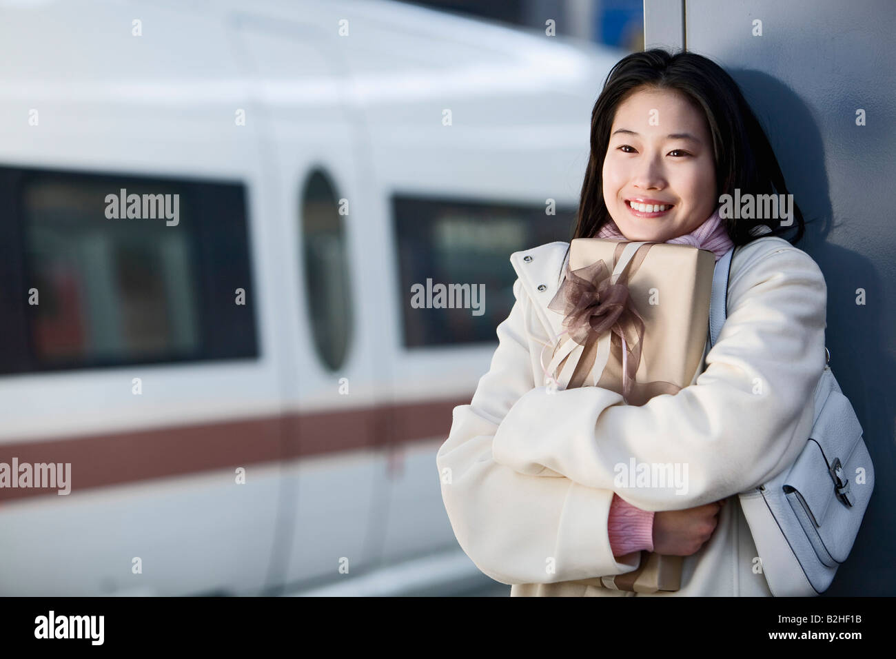 Ritratto di giovane donna giapponese in attesa con la presente alla stazione ferroviaria Foto Stock