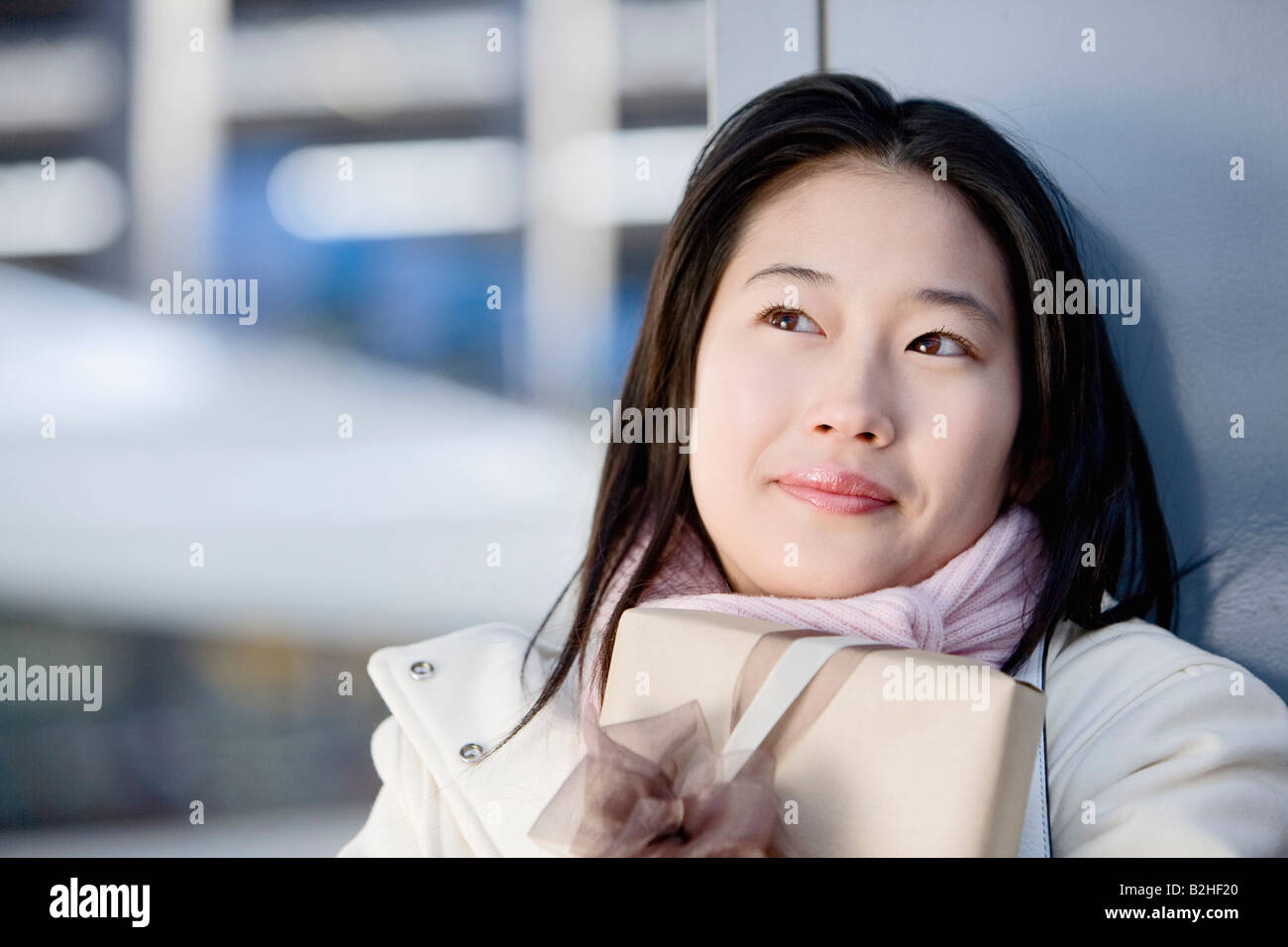 Ritratto di giovane donna giapponese in attesa con la presente alla stazione ferroviaria Foto Stock