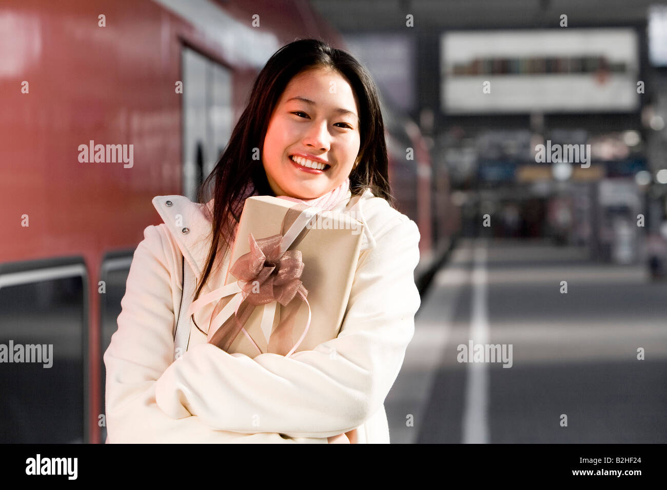 Ritratto di giovane donna giapponese presso stazione ferroviaria tenendo presente Foto Stock