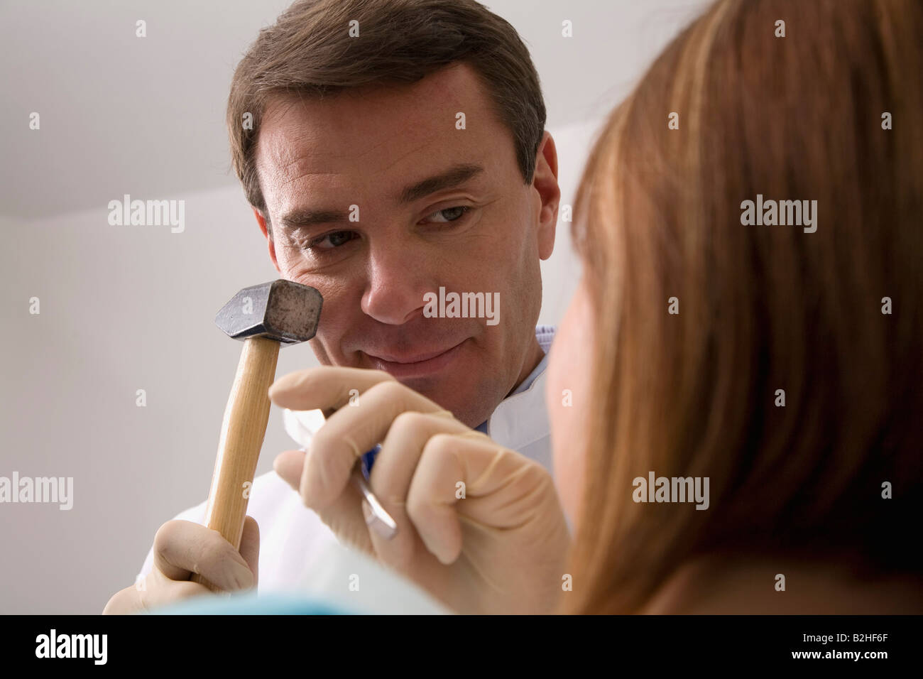 Dentista trattamento paziente femmina con martello e scalpello Foto Stock