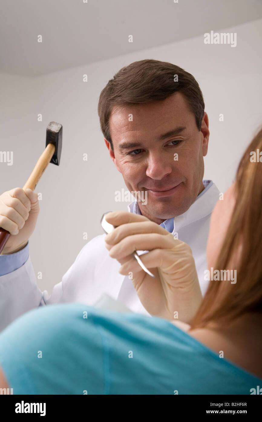 Dentista trattamento paziente femmina con martello e scalpello Foto Stock