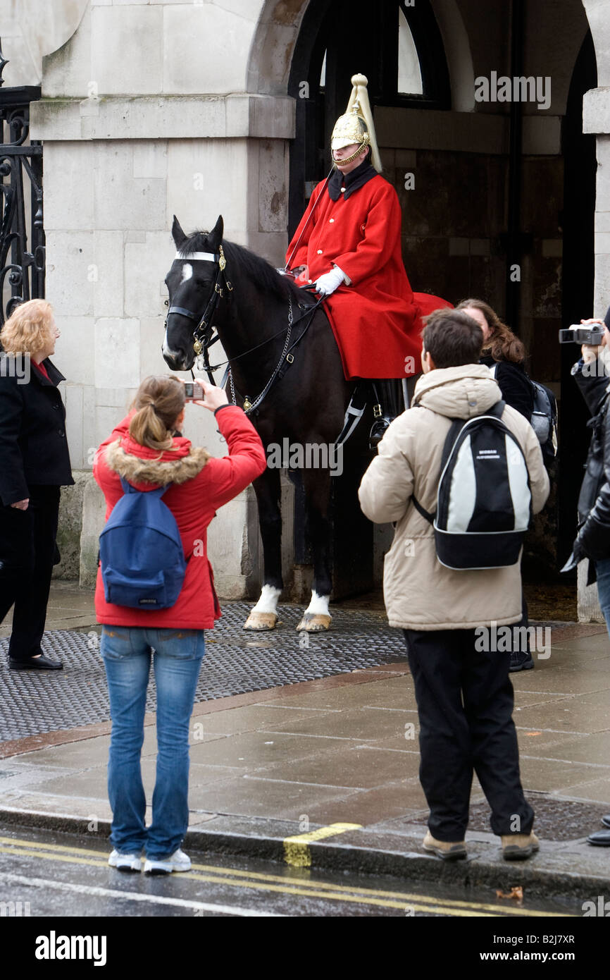 Un Queens Casa Guardia di cavalleria è fotografata da turisti in Whitehall London REGNO UNITO Foto Stock