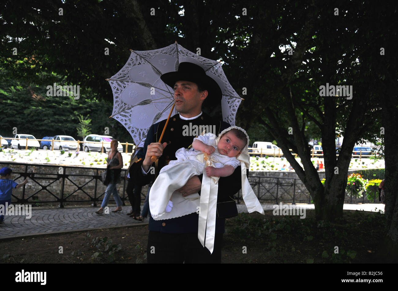 Un uomo con la sua bambina sulle sue braccia sotto ombrellone durante il Festival di Cornovaglia a Quimper in 2008 Brittany Foto Stock