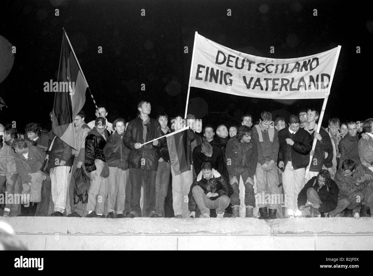 Germania, riunificazione, caduta del muro di Berlino, natale alla porta di Brandeburgo, 22.12.1989, persone con bandiera e bandiera tedesca sul muro di Berlino, Foto Stock