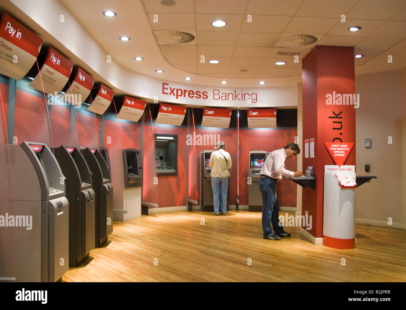 Persone con modalità automatizzate macchine self-service presso una filiale della banca HSBC Foto Stock