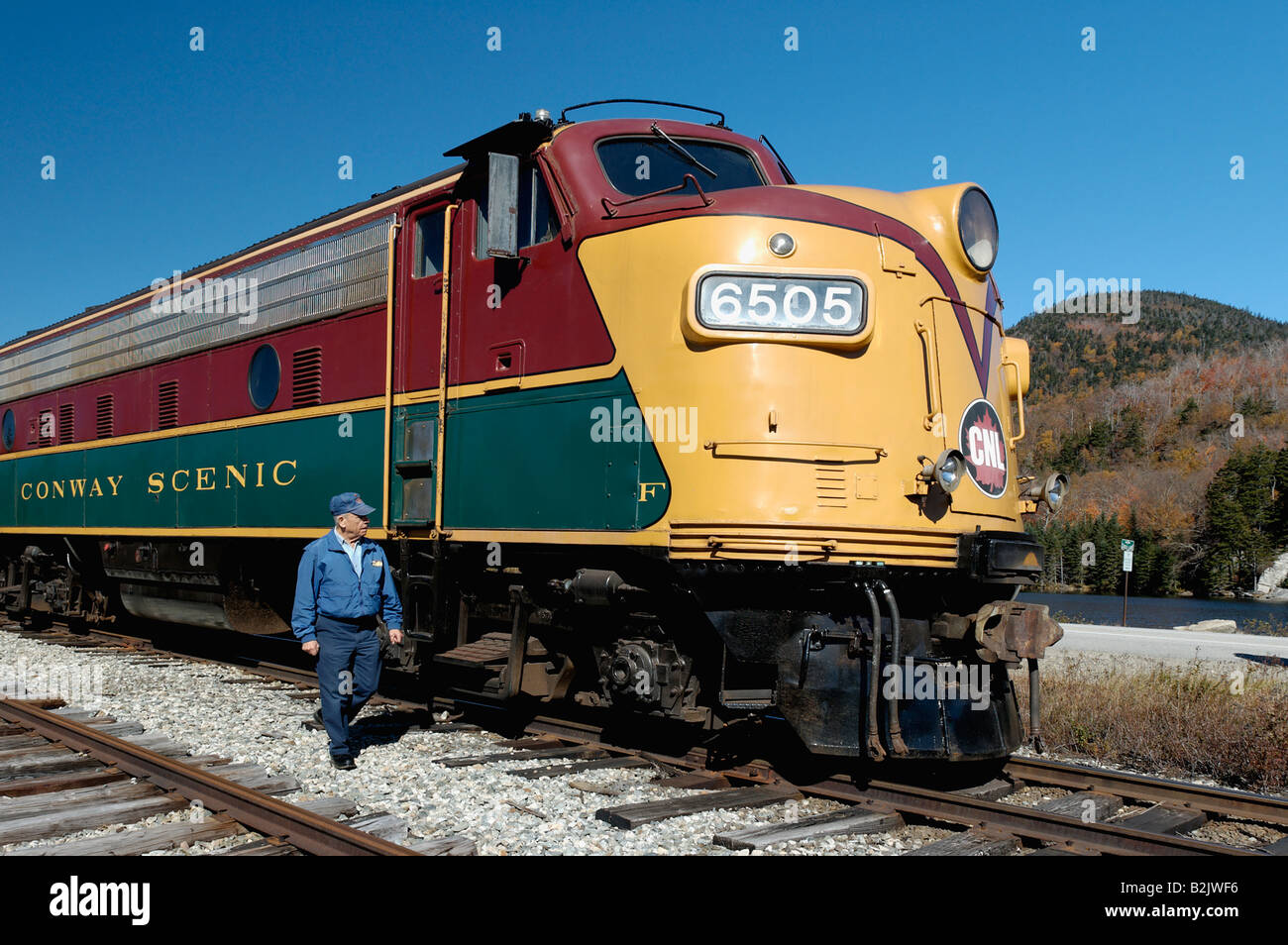 Ingegnere camminando accanto a Diesel Locomotiva Elettrica del Conway Scenic Railroad presso il deposito di Crawford nelle White Mountains Foto Stock