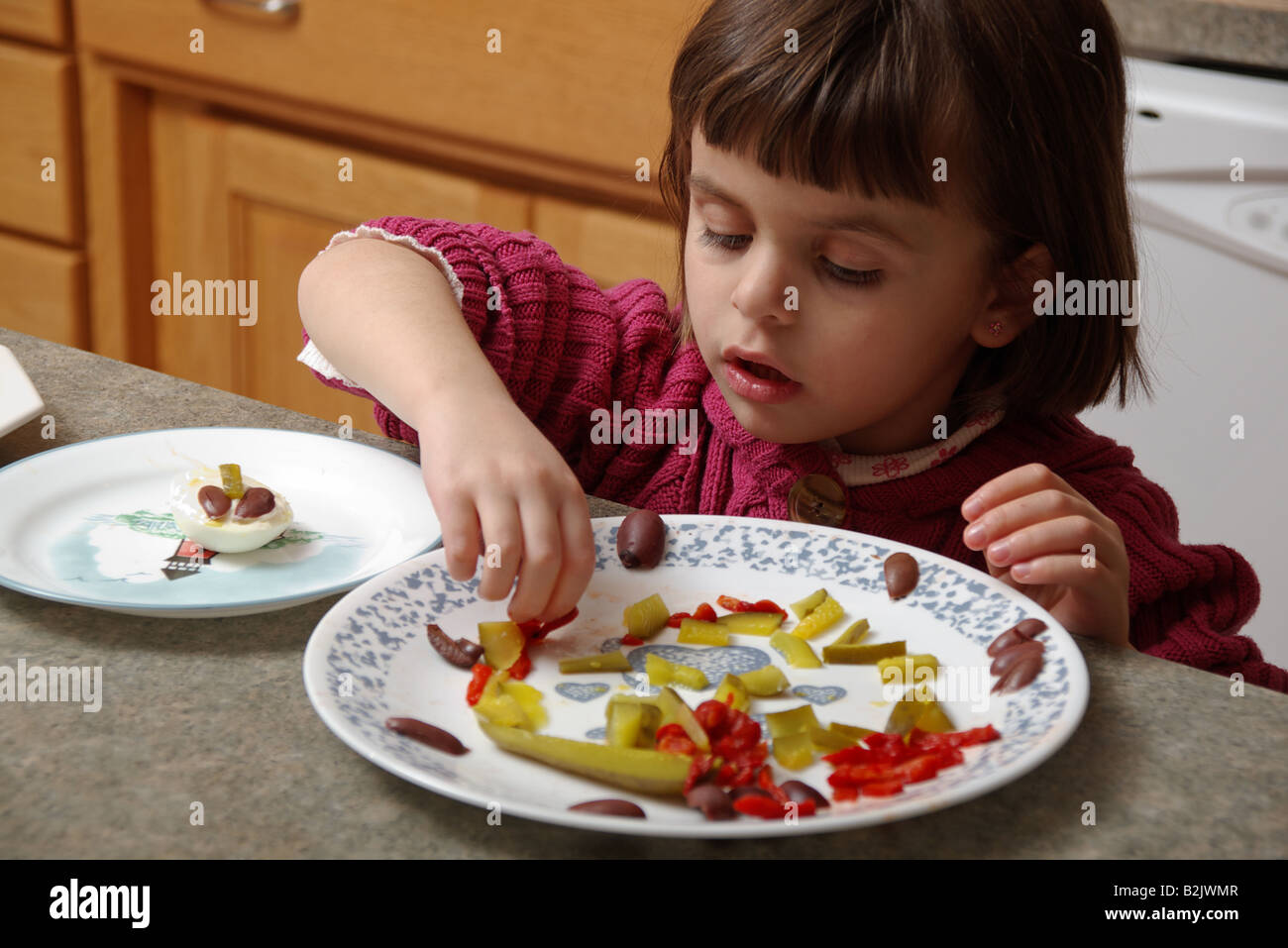 4 anni ragazza aiutando preparare il cibo in cucina Foto Stock