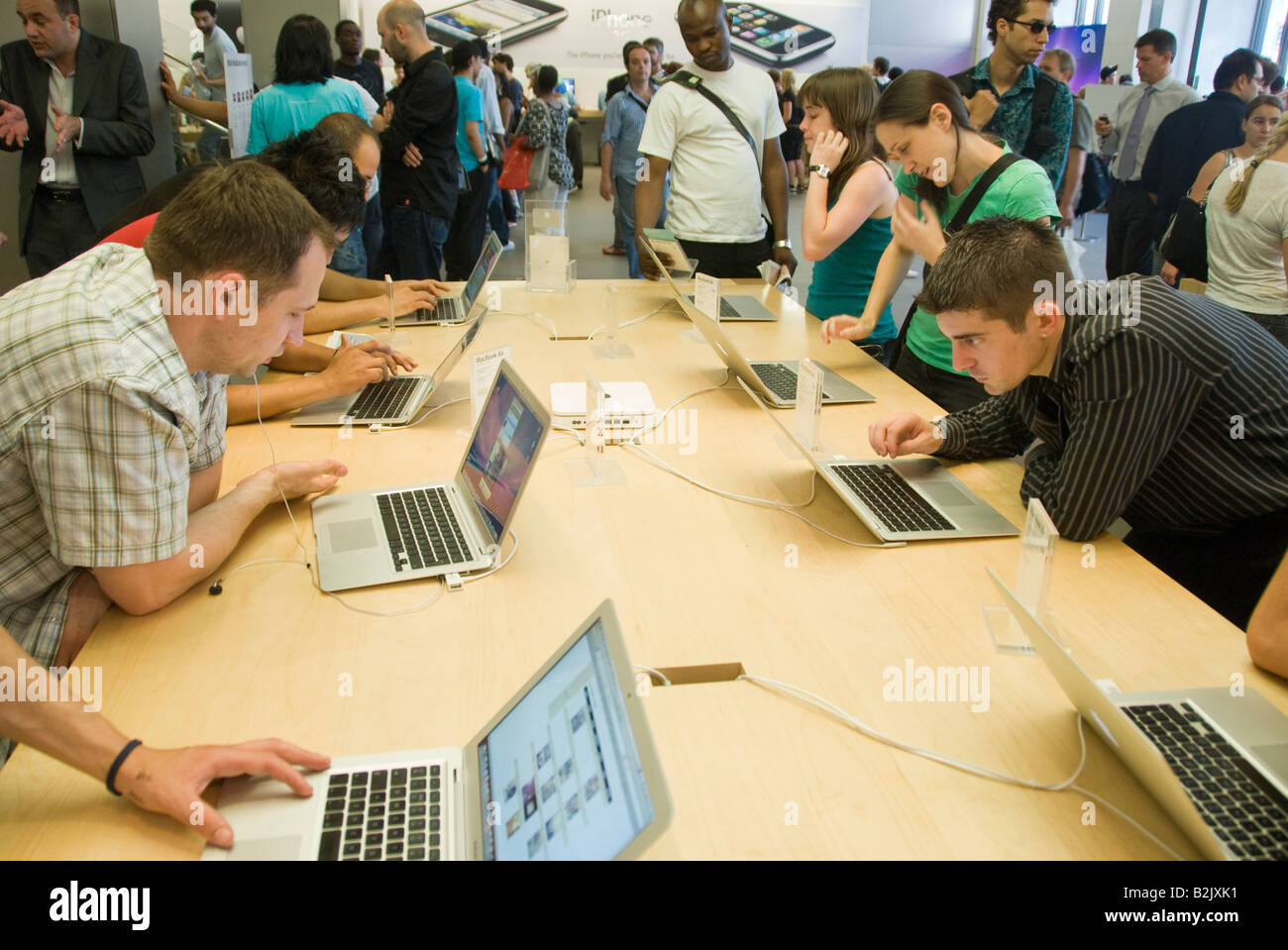 Persone che guardano il nuovo Macbook Air computer portatile nel negozio Apple Store a Londra Foto Stock